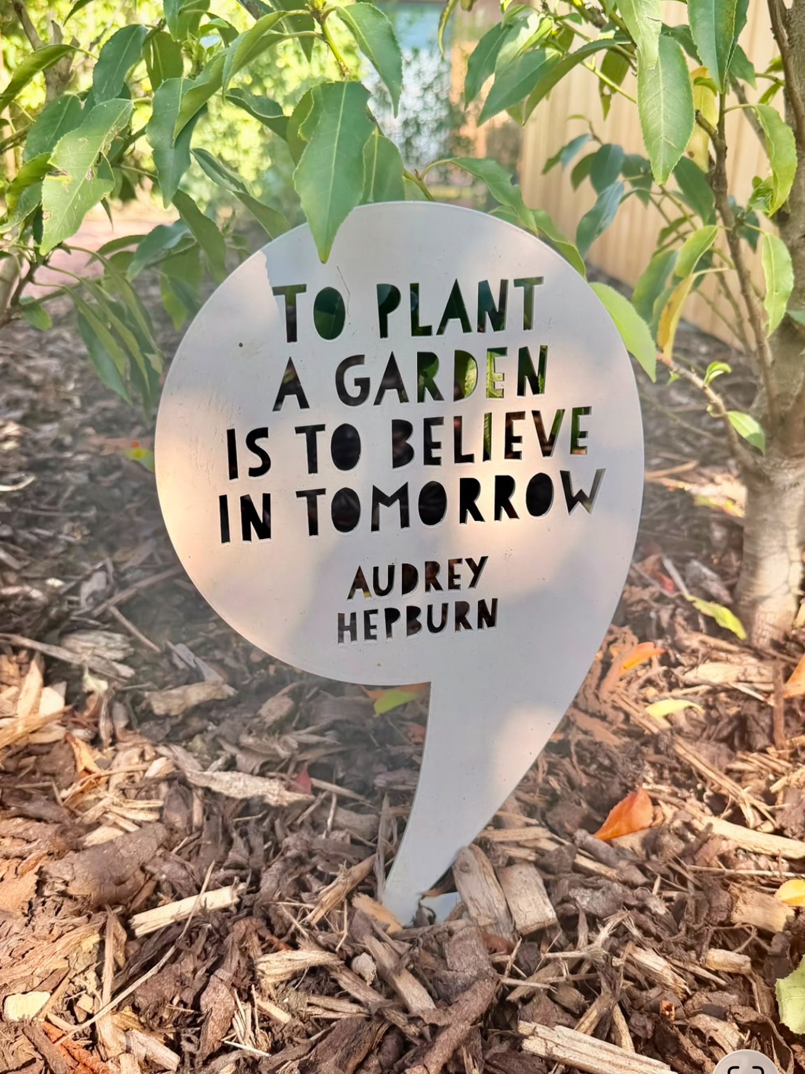 A garden plaque reading To plant a garden is to believe in tomorrow, Audrey Hepburn